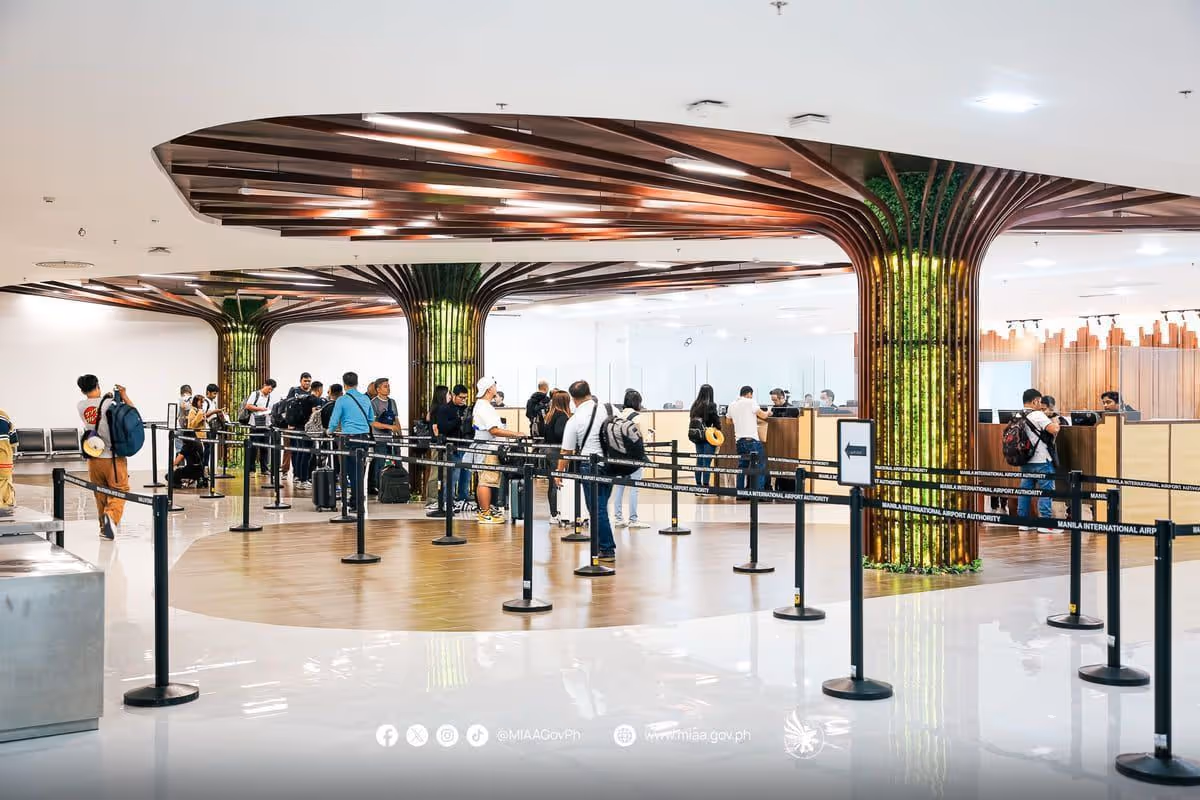 Passport control counters at an airport terminal, with officers seated at inspection booths